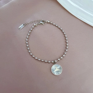 Détail macro du bracelet à perles argentées avec pendentif queue de sirène et fermoir