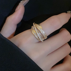 Close-up of gold layered zircon ring with criss-cross design and shimmering white stones