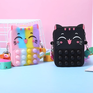 Close-up of cat-shaped silicone pop fidget bags in rainbow and black with adjustable straps