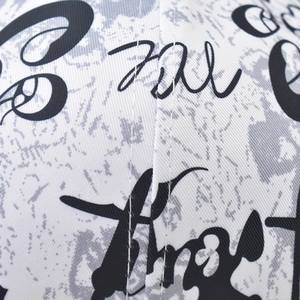 Close-up of white twill fabric with graffiti letter print and durable white stitching