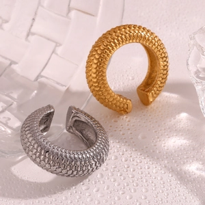 Macro shot of 18K gold and silver fish scale textured C-shape metal earrings detail