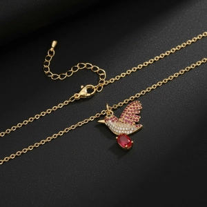 Golden hummingbird necklace with red and white zircons and an oval red gemstone