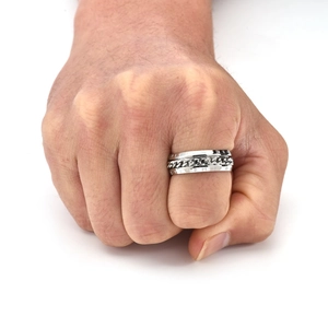 Detail shot of a silver spinning chain ring with Roman numerals on a model's finger