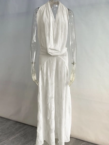 Detail of white halter neck maxi dress featuring a deep V-neck and floral leaf jacquard texture
