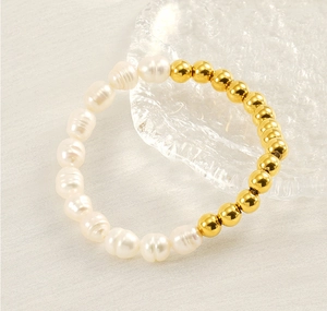 Détail de perles d'eau douce et billes dorées sur un bracelet à l'éclat naturel