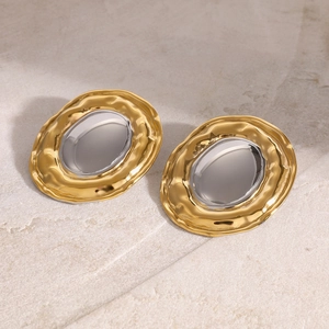 Macro detail of two-tone gold and silver irregular earrings with hammered texture