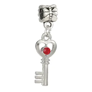 Detail of silver alloy heart key charm with red crystal for DIY bracelet making
