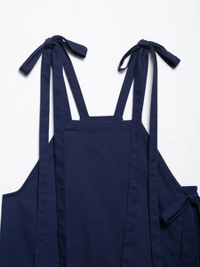 Detail of navy blue linen top with bow-knot shoulder straps and fabric texture
