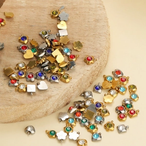 Close-up of colorful cubic zirconia charms in heart and flower shapes with gold settings