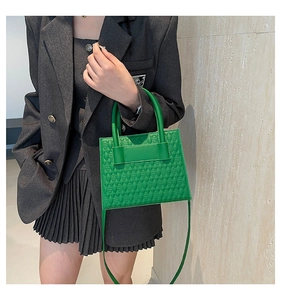 Close-up of bright green embossed geometric texture handbag with matching straps