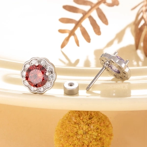 Flower-shaped zircon stud earrings with red center stone and screw back design