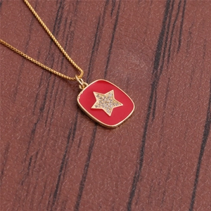 Detailed close-up of red enamel star pendant with micro-pave zircons on gold box chain