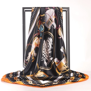 Carré en satin avec imprimé carrosse noir et or et bordure orange sur support de vente