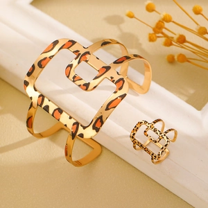 Detalle del conjunto de brazalete y anillo geométrico con estampado de leopardo dorado