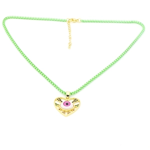Dettaglio del ciondolo a cuore con malocchio rosa e catena verde su sfondo bianco
