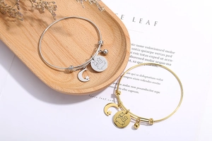 Detail of adjustable star and moon charm bracelets in gold and silver finish