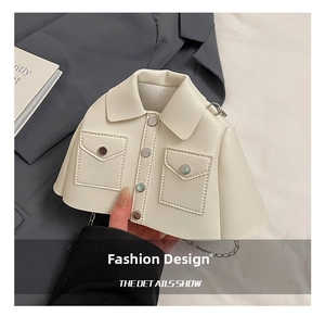 Close-up of cream white jacket-shaped mini crossbody bag with metal buttons and chain