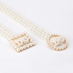 Detailed view of women's elegant pearl waist chain with golden metal buckles on white background