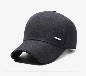 Detail of dark grey denim baseball cap featuring metal Sport badge and brim lettering
