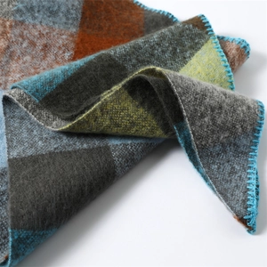 Macro detail of multicolored plaid scarf with soft texture and blue stitched edges