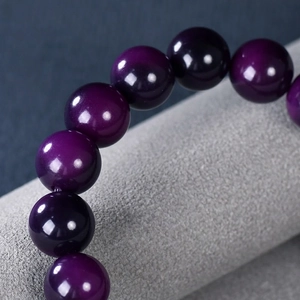 Handcrafted purple Bodhi root bead bracelet for meditation on a gray velvet stand