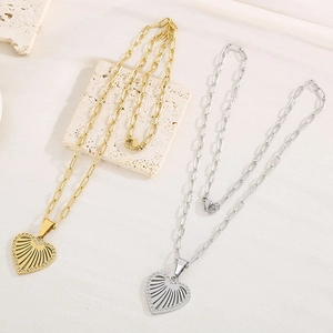 Detail of heart-shaped pendants with hollow fan designs in gold and silver finishes