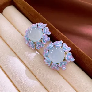 Elegant floral stud earrings with blue gemstone and pink roses in a luxury gift box