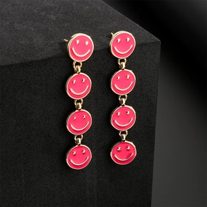 Gold-trimmed long earrings featuring four linked pink enamel smiley face charms
