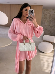 Detail eines rosa Satin-Kleides mit V-Ausschnitt, dekorativen Bändern und Laternenärmeln