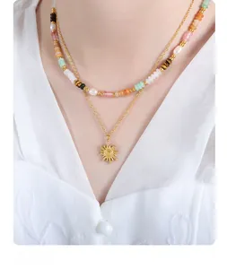 Detail of double-layer necklace with sun pendant and colorful beads on a model