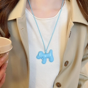 Gros plan d'un collier pendentif chien en émail bleu clair sur cordon tressé