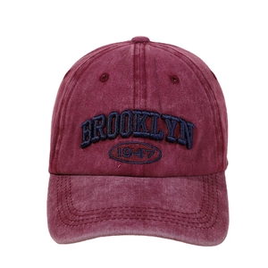 Vintage washed red cotton baseball cap with Brooklyn 1947 embroidery on white background