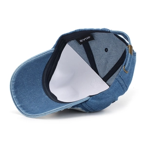 Detail of adjustable brass buckle and denim texture on the back of the baseball cap