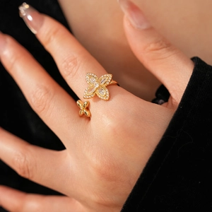 Détail d'une bague dorée réglable ornée de deux fleurs et de zircons brillants de haute qualité