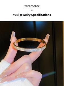 Detail view of gold titanium steel bangle with three rows of sparkling crystal stones