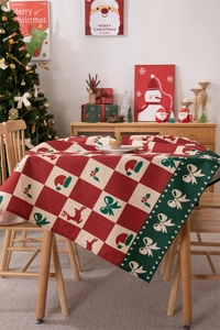 Detailed Christmas tablecloth pattern with red reindeer motifs on a cozy wooden table