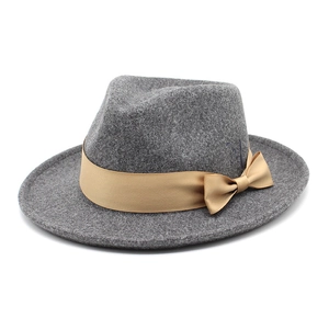 Detail of grey wool fedora hat with a wide champagne gold satin ribbon and side bow