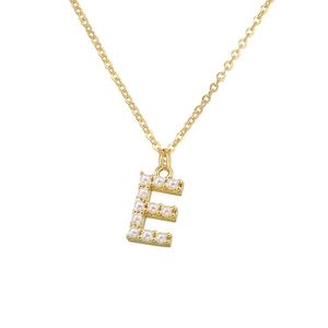 Close-up of golden letter E necklace pendant inlaid with white elegant pearls