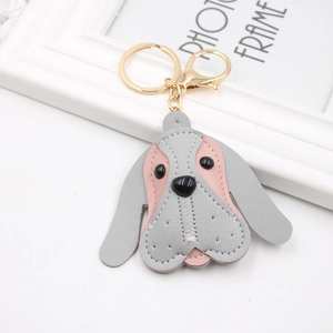 Detail of beagle dog leather keychain with pink and grey finish and gold clasp