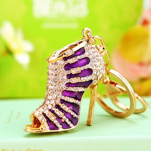 Close-up of sparkling purple rhinestone high heel keychain with golden metal ring