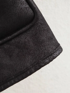 Détail des coutures et de la texture grainée de la veste en similicuir noir