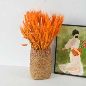 Natural seagrass woven flower basket with bright orange dried wheat stalks decoration