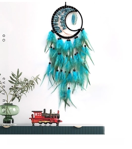Detail of moon dreamcatcher featuring life tree crystal and peacock blue feathers