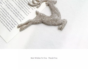 Detail of champagne gold glitter reindeer ornament placed on a vintage book page