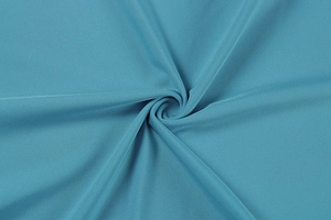 Gros plan sur le tissu plissé bleu paon montrant la texture en maille et le drapé fluide