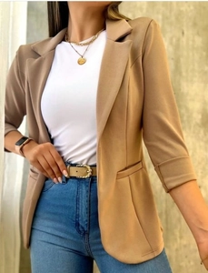 Detalle de chaqueta americana caqui para mujer con cuello de solapa y bolsillos