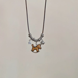 Detailed close-up of a wooden rocking horse necklace with silver star and planet charms