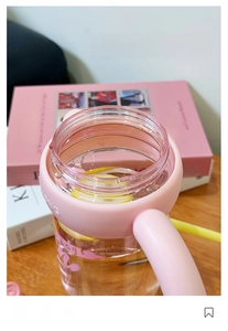 Macro-opname van een grote drinkfles met roze handvat en verse schijfjes citroen erin