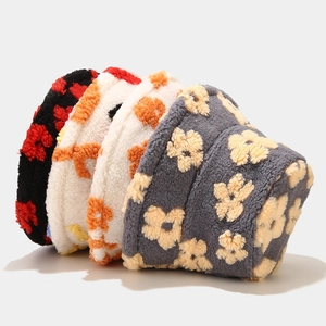 Stack of fuzzy floral bucket hats in black, white, beige and grey lamb wool material