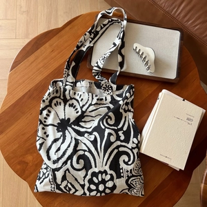 Sac cabas bohème en lin avec imprimé floral noir et blanc sur table en bois rustique